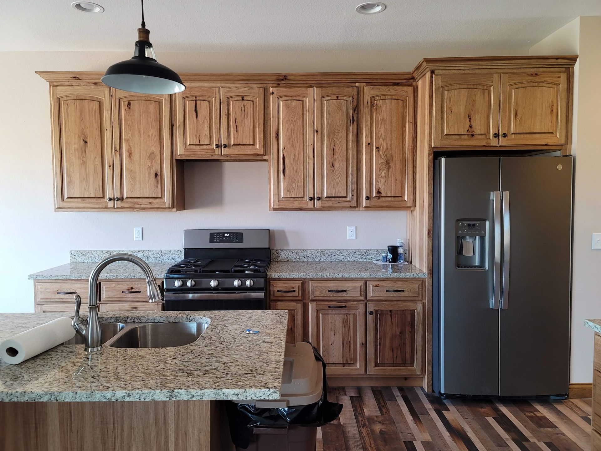 A kitchen with wooden cabinets and a stainless steel refrigerator
