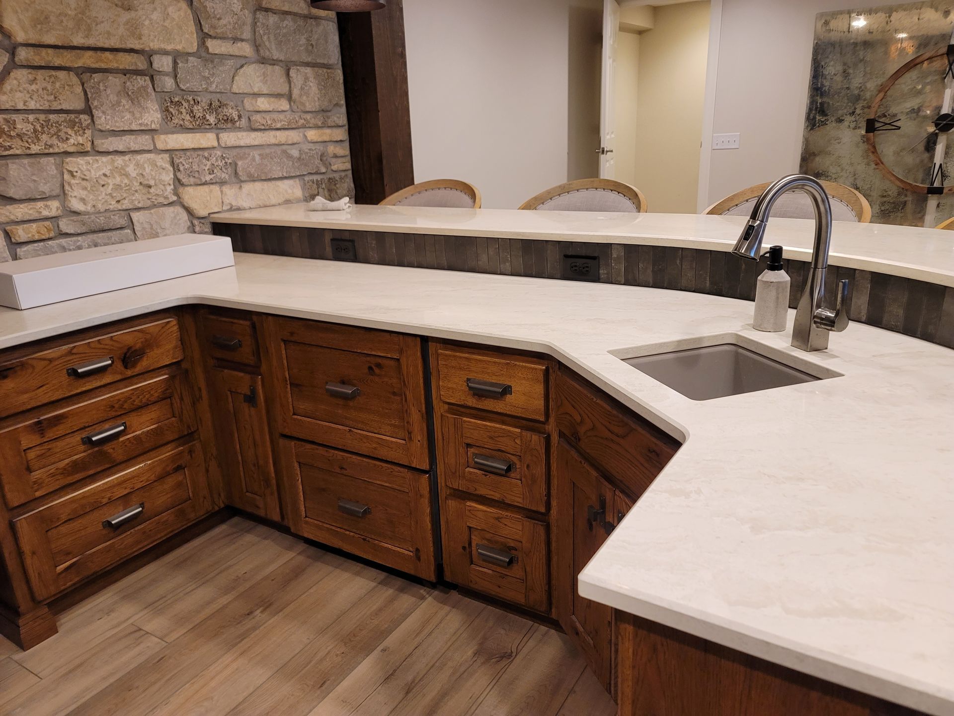 A kitchen with wooden cabinets , white counter tops and a sink.