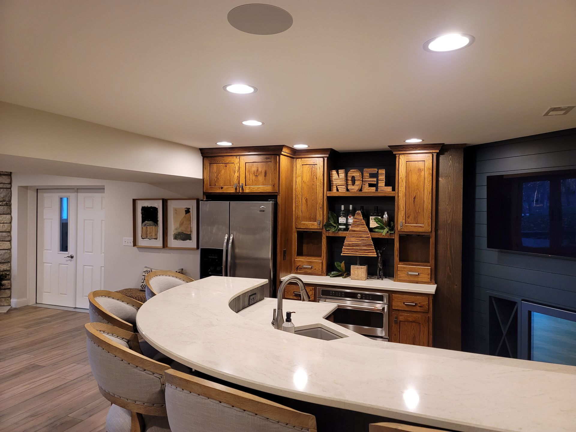 A kitchen with a curved counter top and a refrigerator.