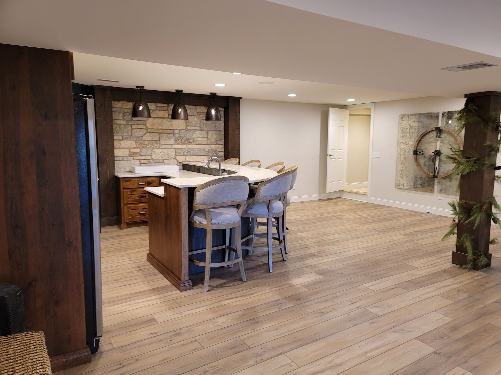 A basement with a kitchen and a bar in it.