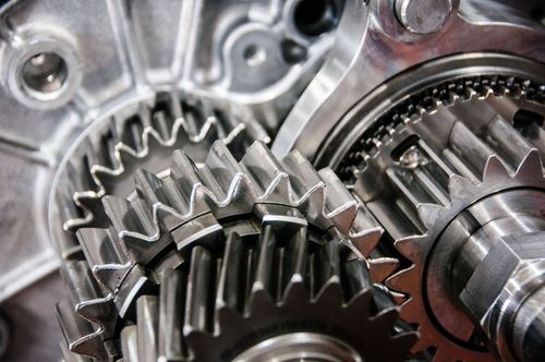 Close-up of shiny metal gears and gears teeth in a mechanical assembly