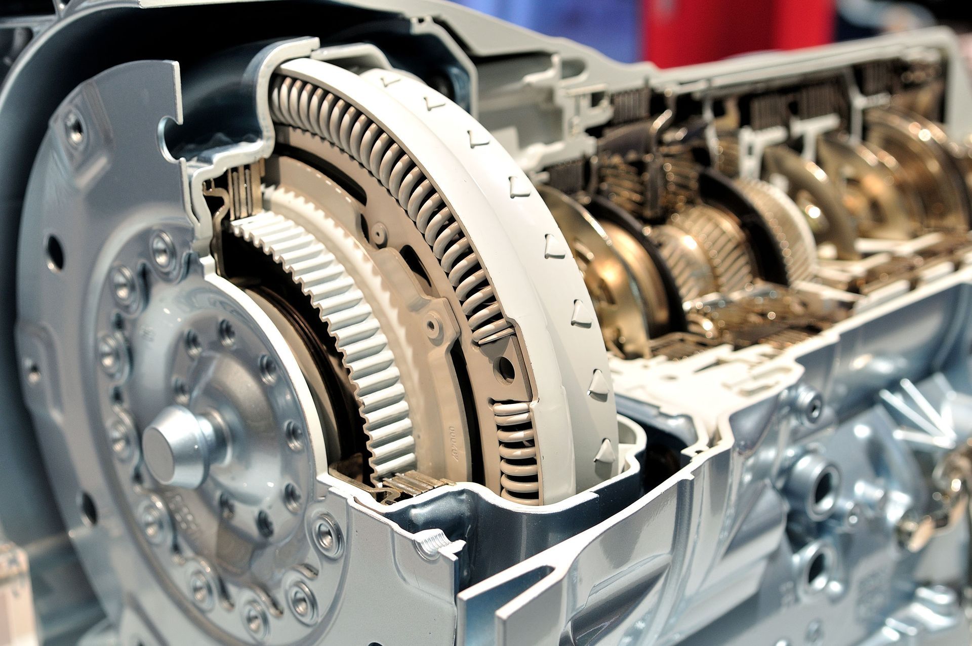 Cutaway of a car transmission showing gears and a torque converter inside a metal housing