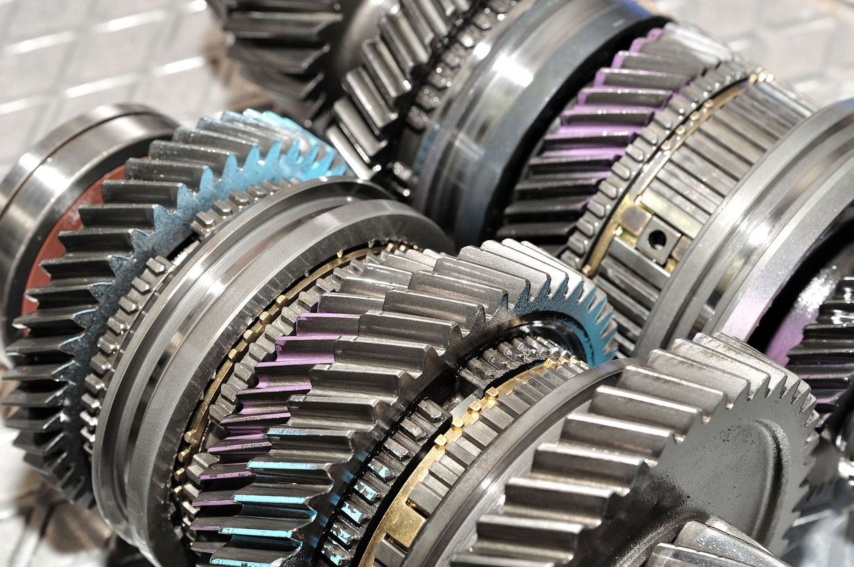 Close-up of shiny metal gears and mechanical parts stacked together in a factory setting