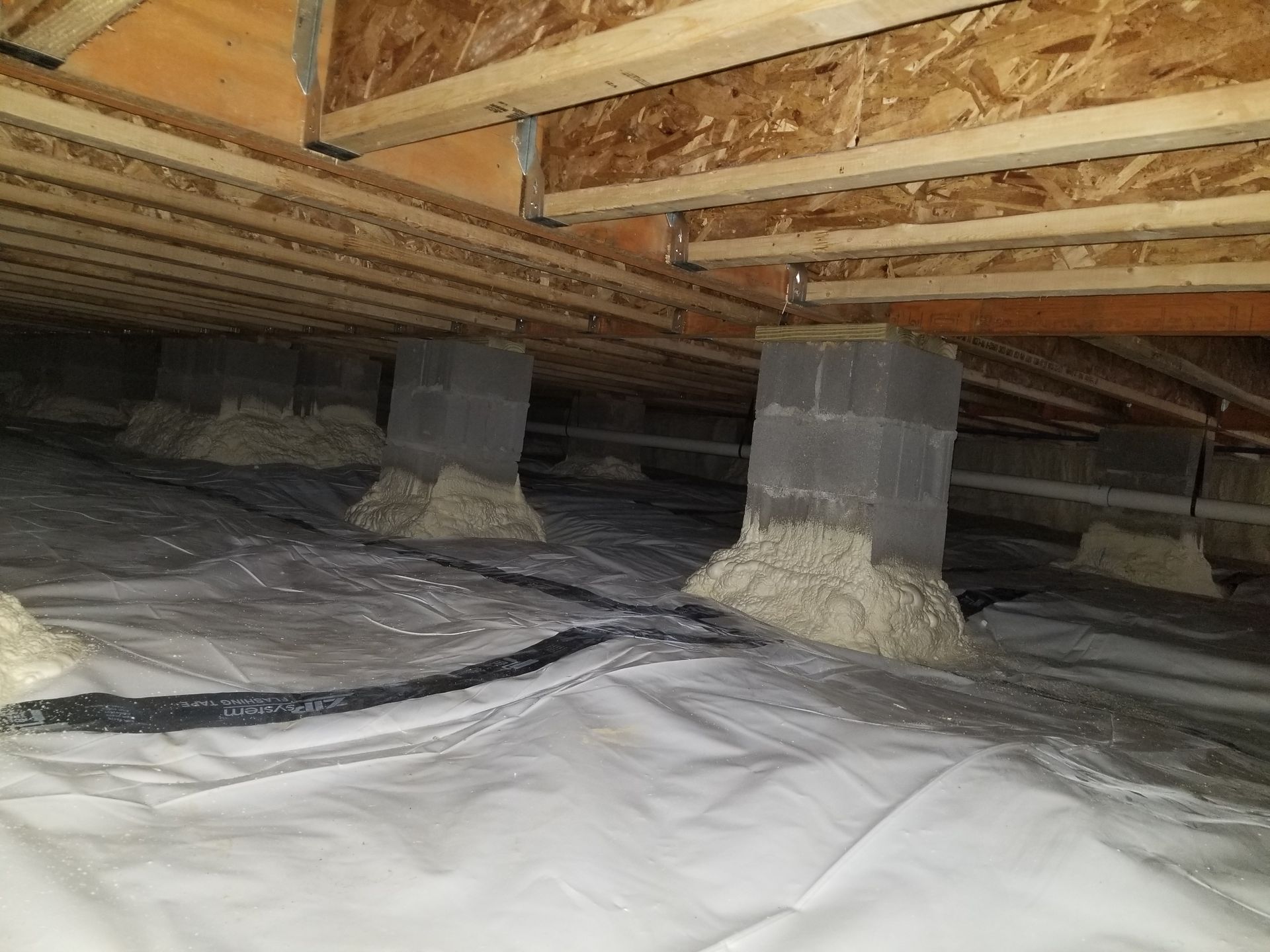 There is a lot of insulation in the crawl space of a house.
