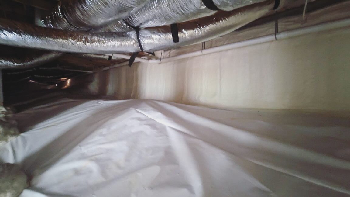 A room with a lot of pipes and a white sheet on the floor.