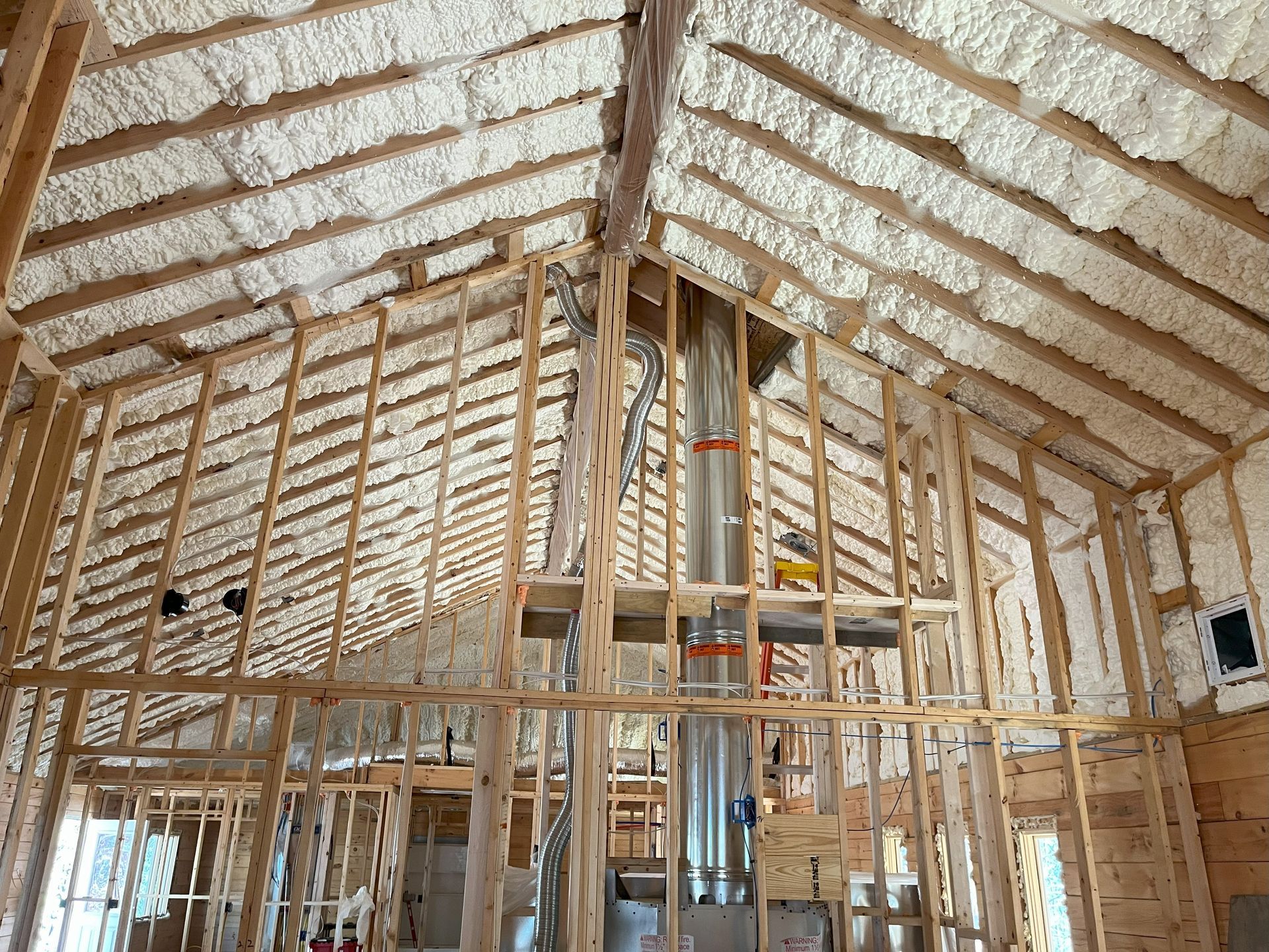 The inside of a house under construction with foam on the ceiling.