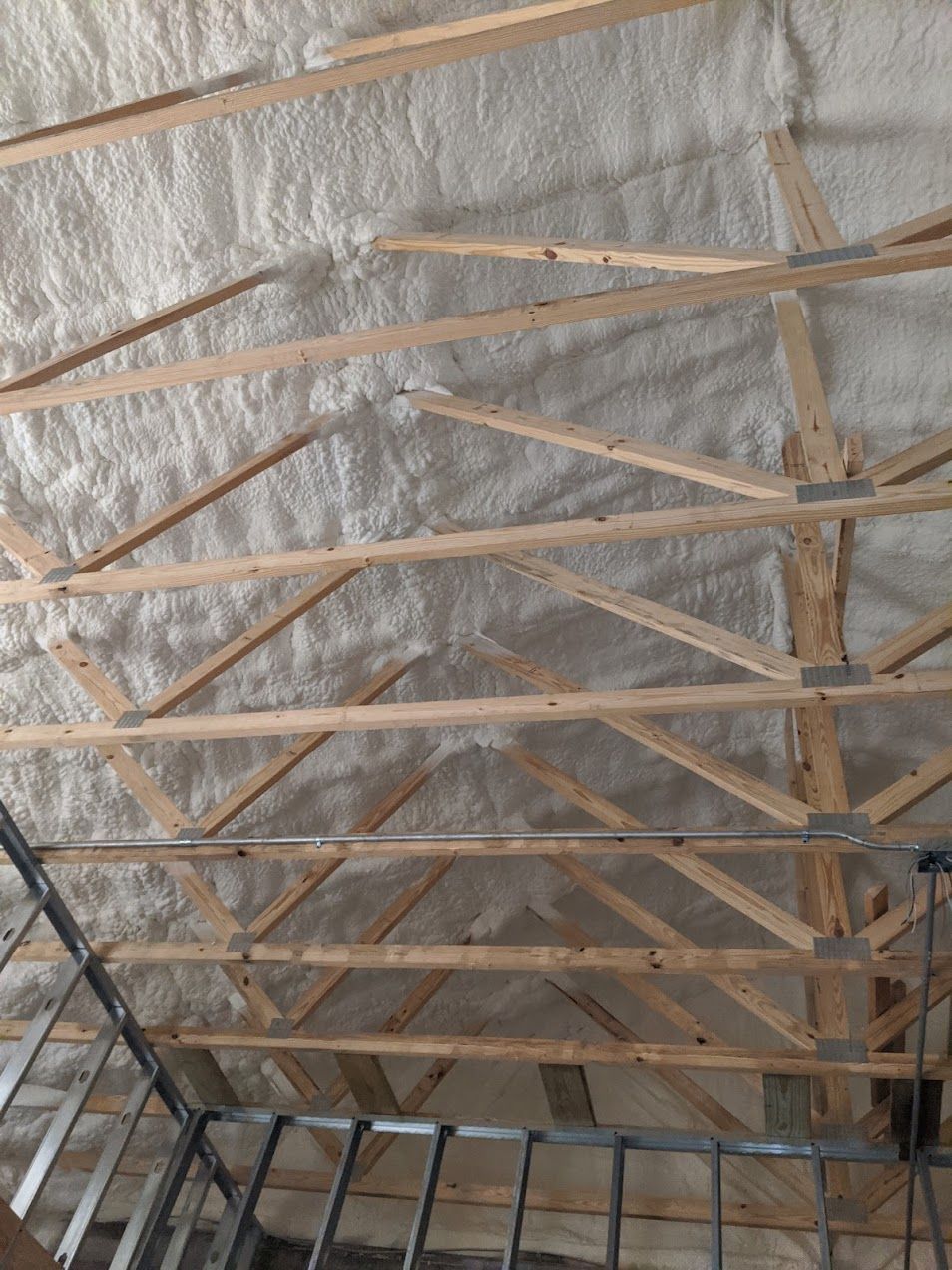 A ceiling with a lot of foam on it and wooden beams.
