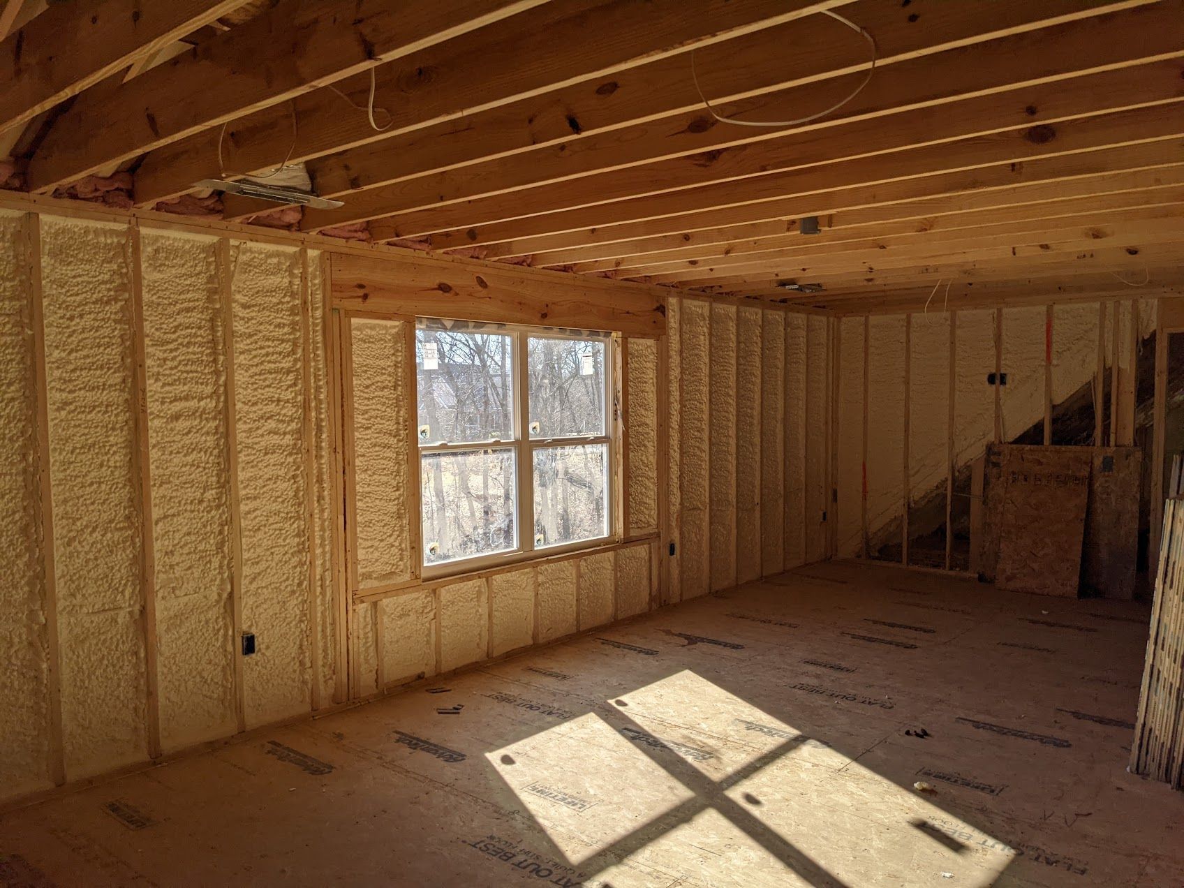 A room with a lot of insulation on the walls and ceiling and a window.