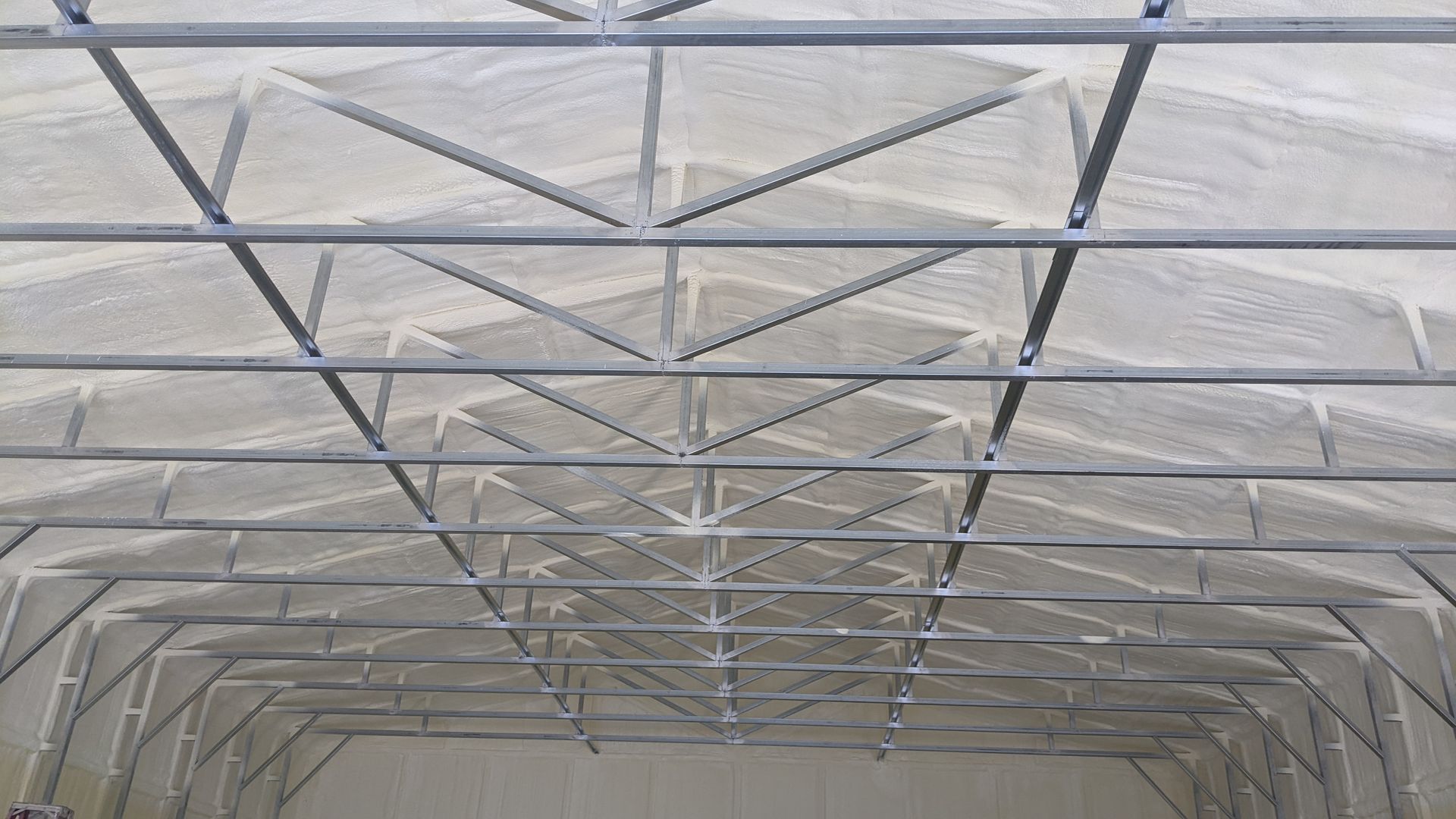 The ceiling of a building with a lot of metal beams.