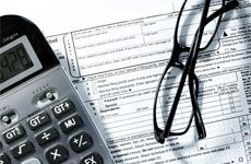 Image of a Tax form, calculator and pen on the table
