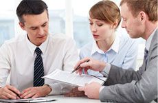 Photo of confident employees discussing papers at meeting
