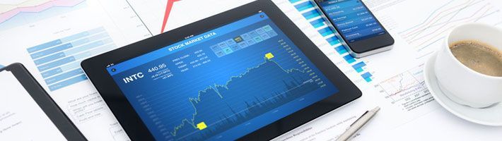 Modern business workplace with stock market data application on a digital tablet