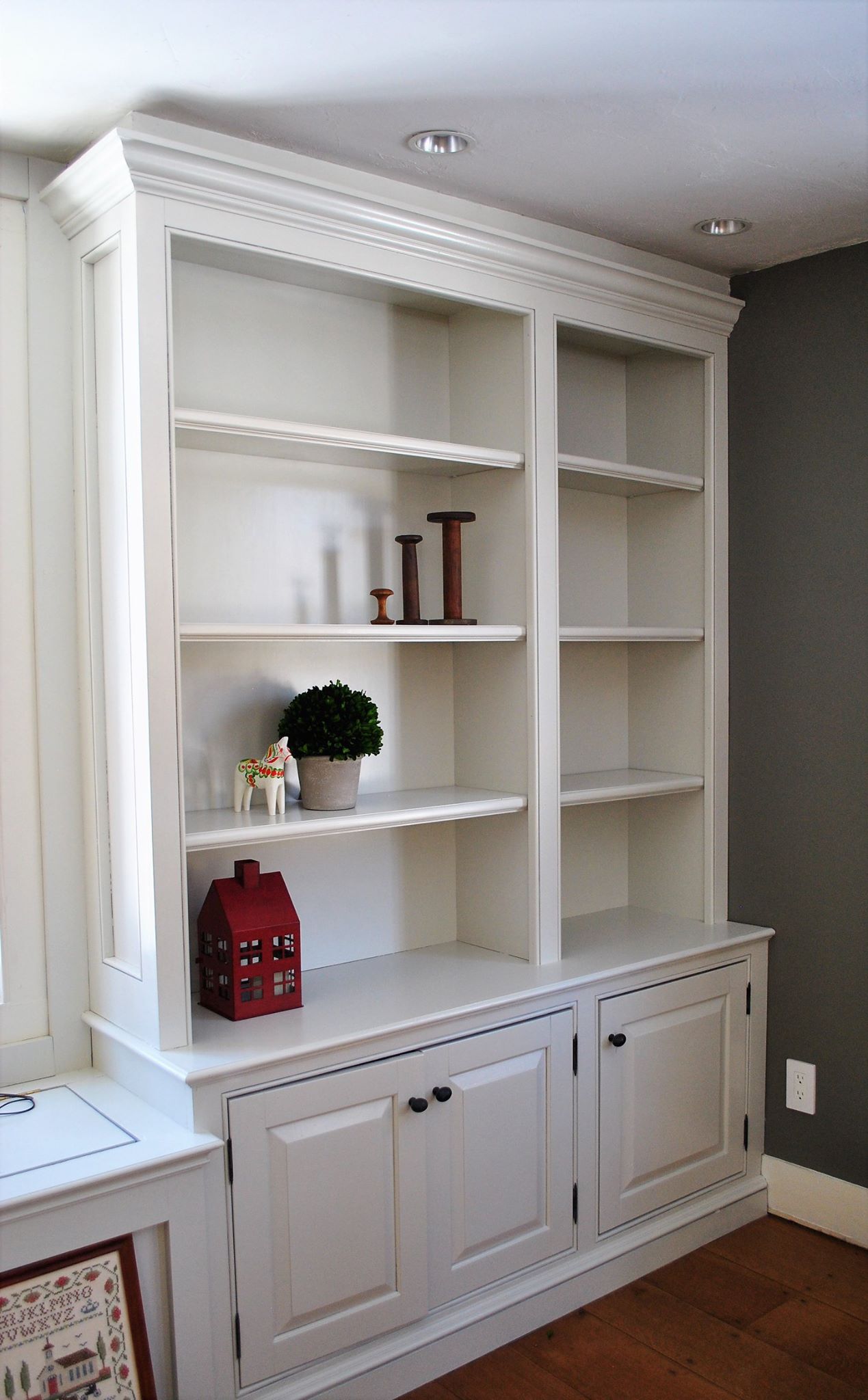 Modern kitchen with white cabinets, dark countertops, stainless steel appliances, and an island with a sink and stools.