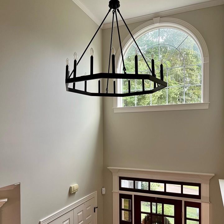 A chandelier is hanging from the ceiling in front of a window