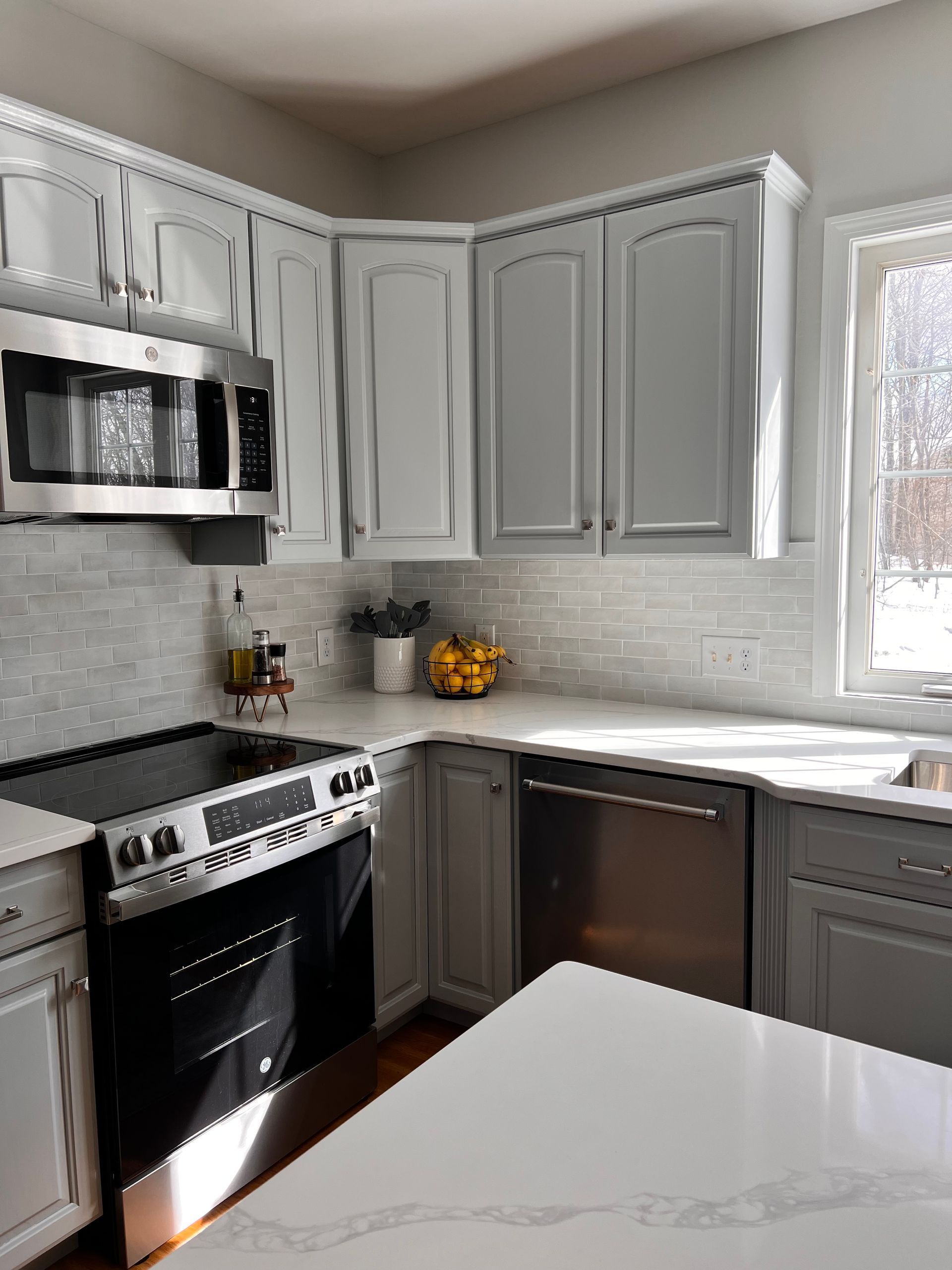 A kitchen with white cabinets and countertop