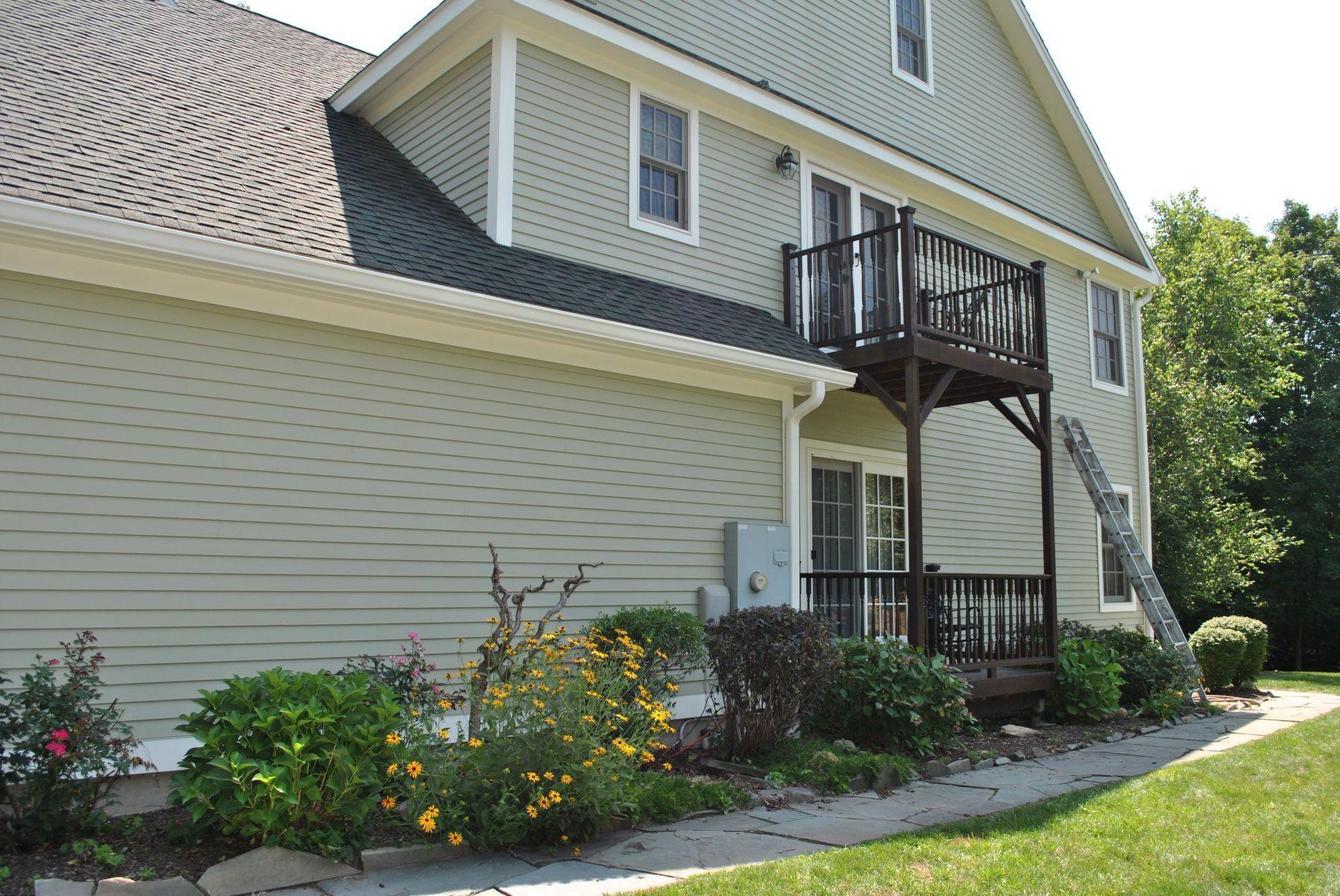 A house with a deck and a ladder on the side of it