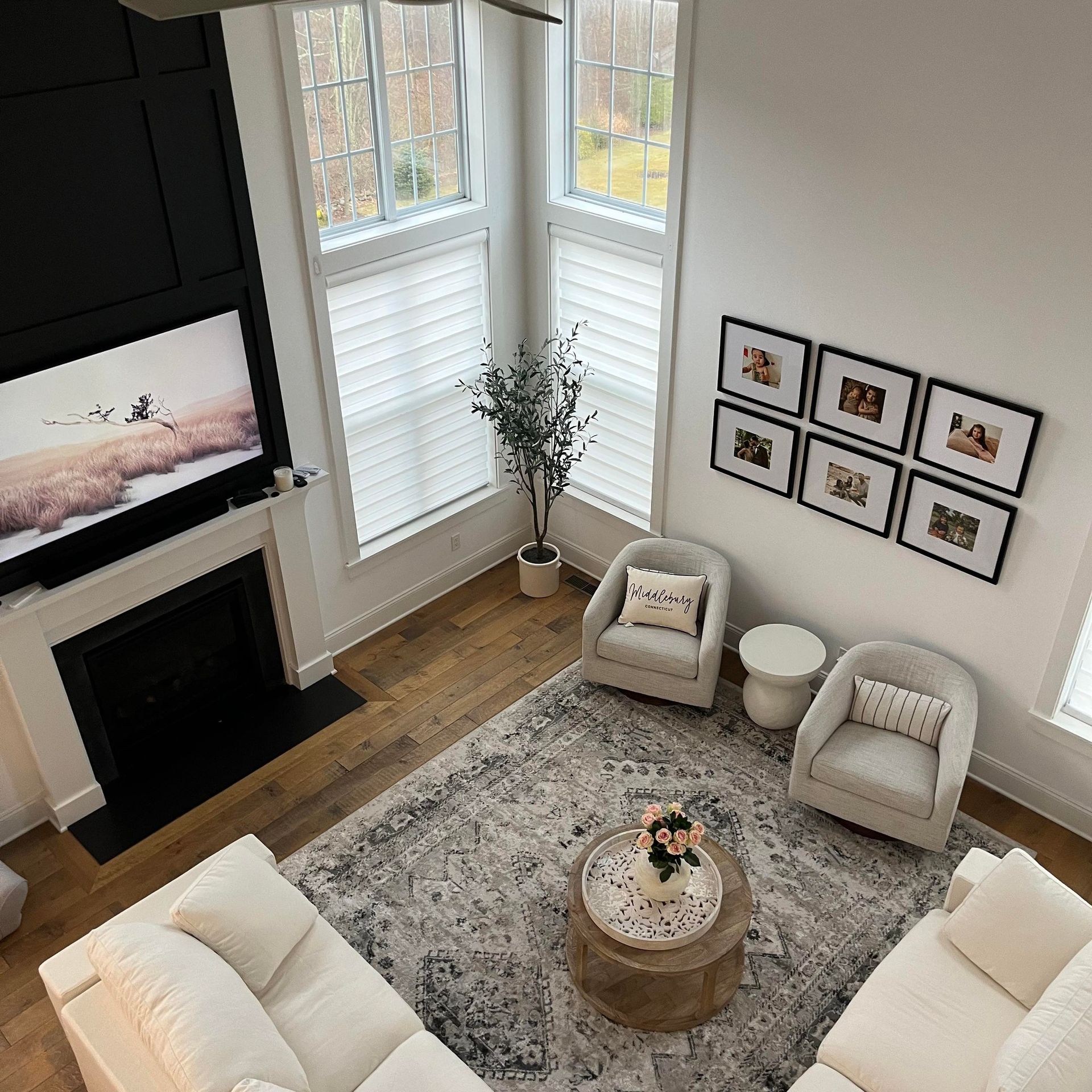 An aerial view of a living room with white furniture and a fireplace.