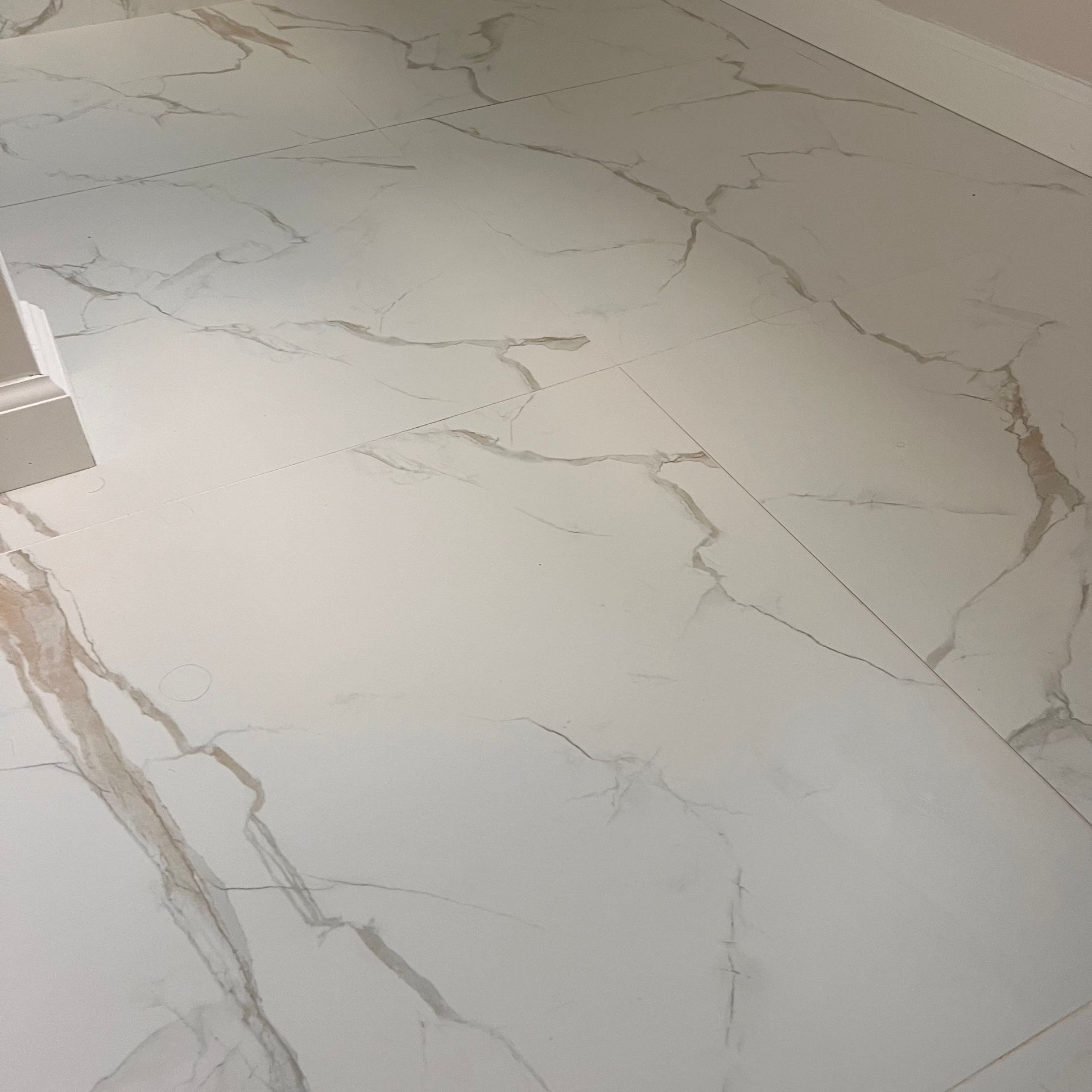 White tiled floor with marble-like veining, creating a pattern across the surface.