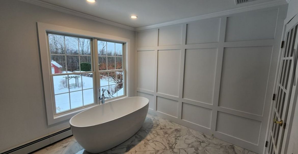 A bathroom with a bathtub and a window.