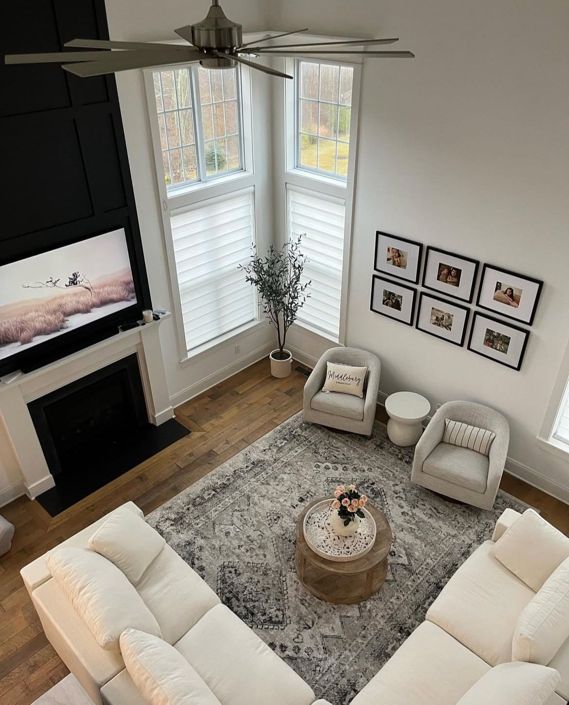 An aerial view of a living room with white furniture and a fireplace.