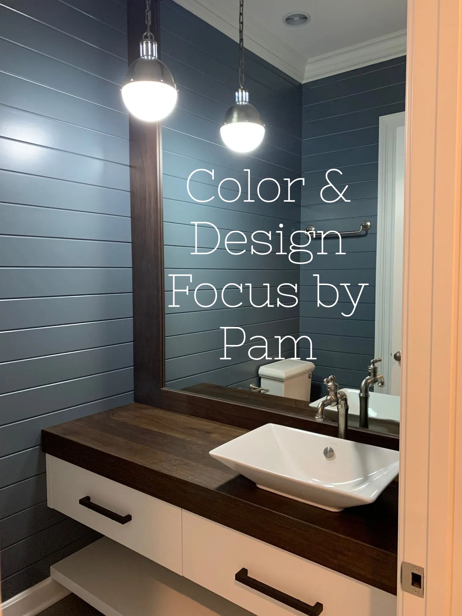 Modern bathroom with blue shiplap walls, dark wood countertop, white vanity, and a square white sink. Two pendant lights hang above.