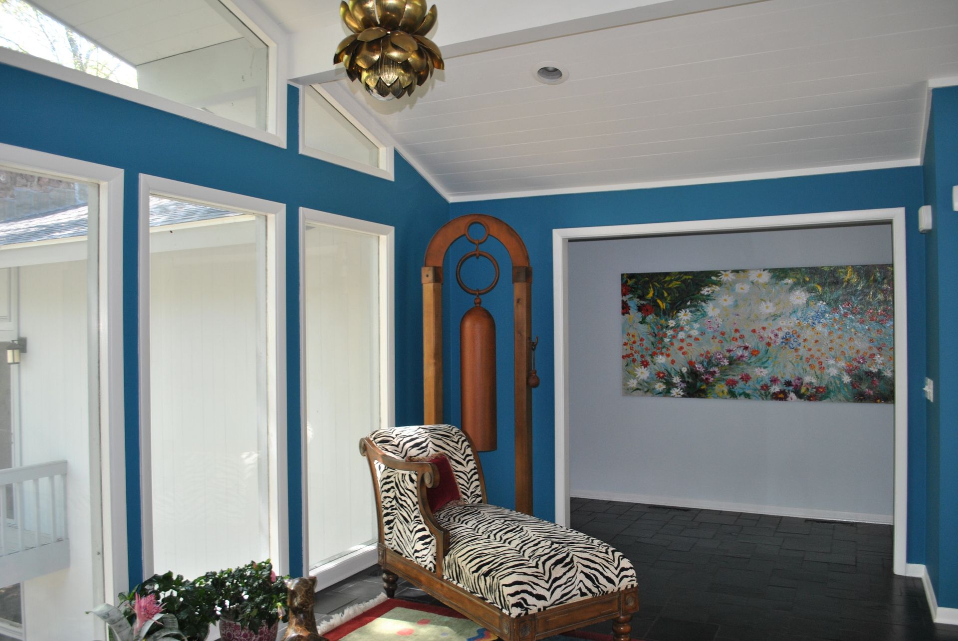 A living room with blue walls and a zebra print chair