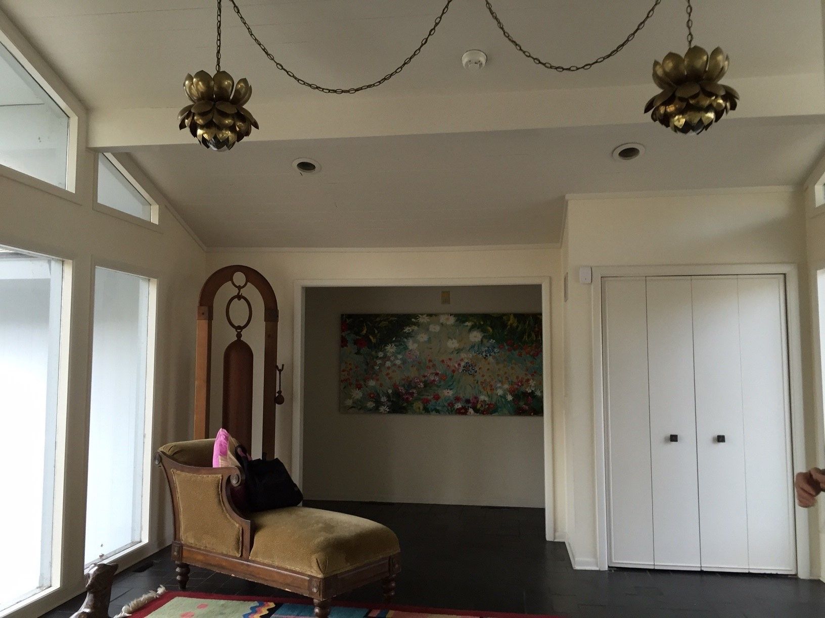 A living room with a chaise lounge and a painting on the wall