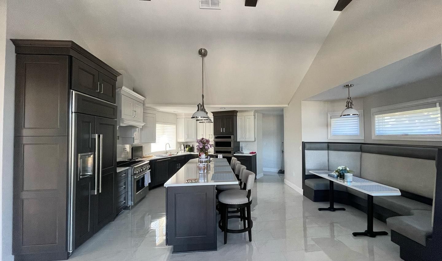 Modern kitchen with dark cabinetry, large island with seating, and a built-in booth.