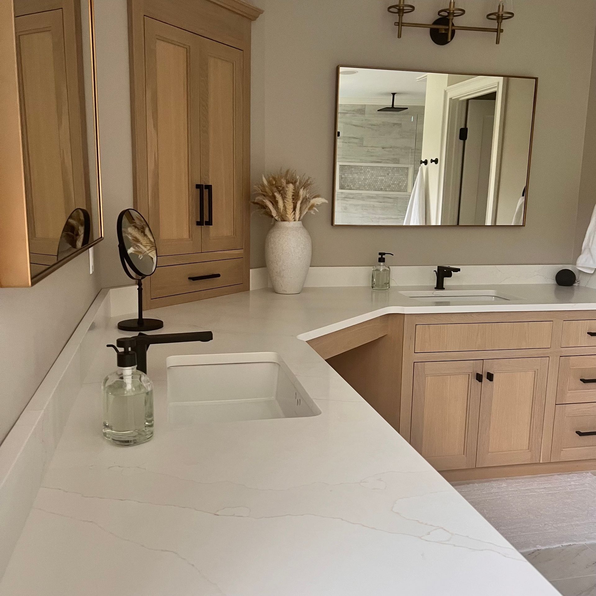 Bathroom with white countertop, light wood cabinets, and a mirror.