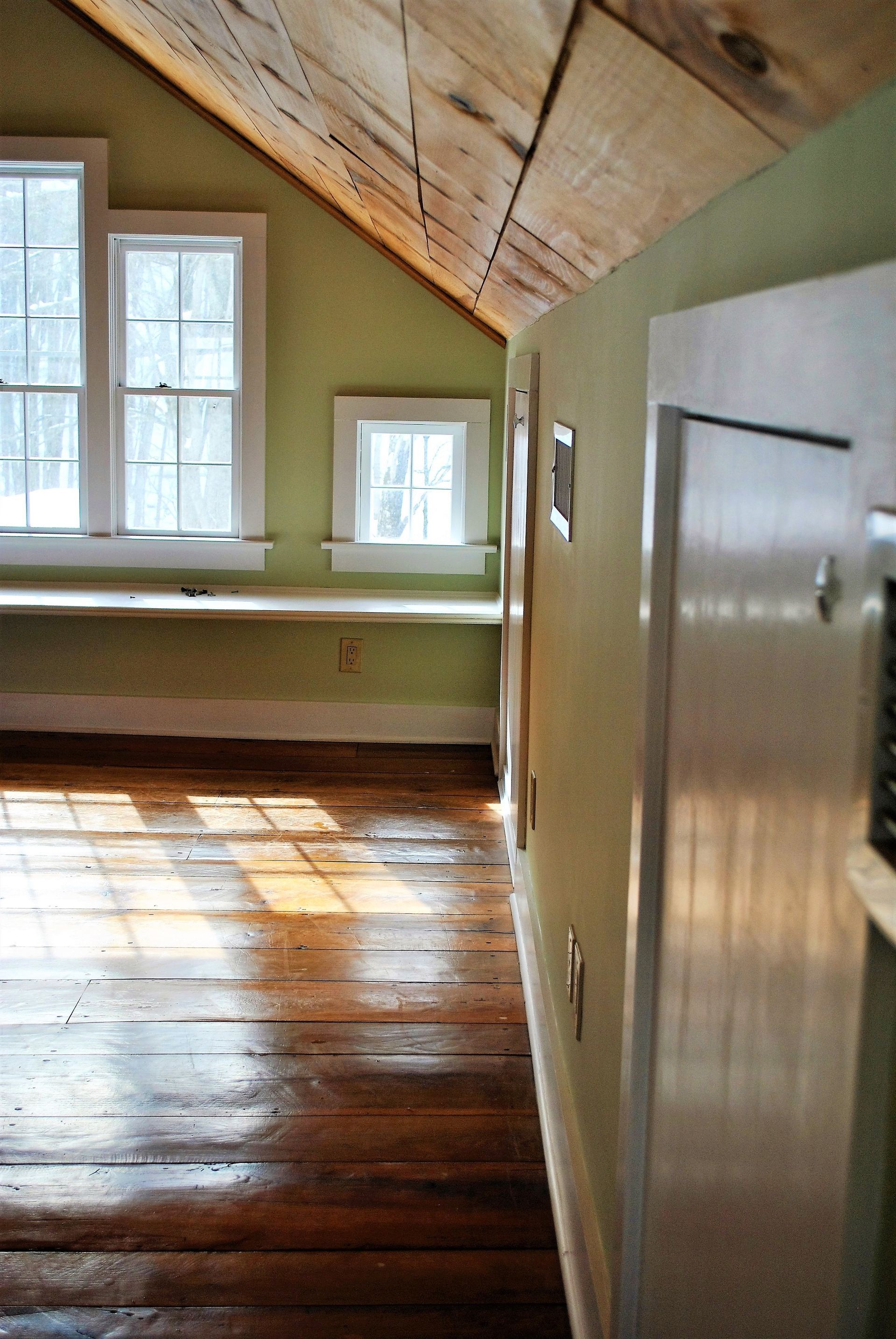 An empty room with wooden floors and green walls