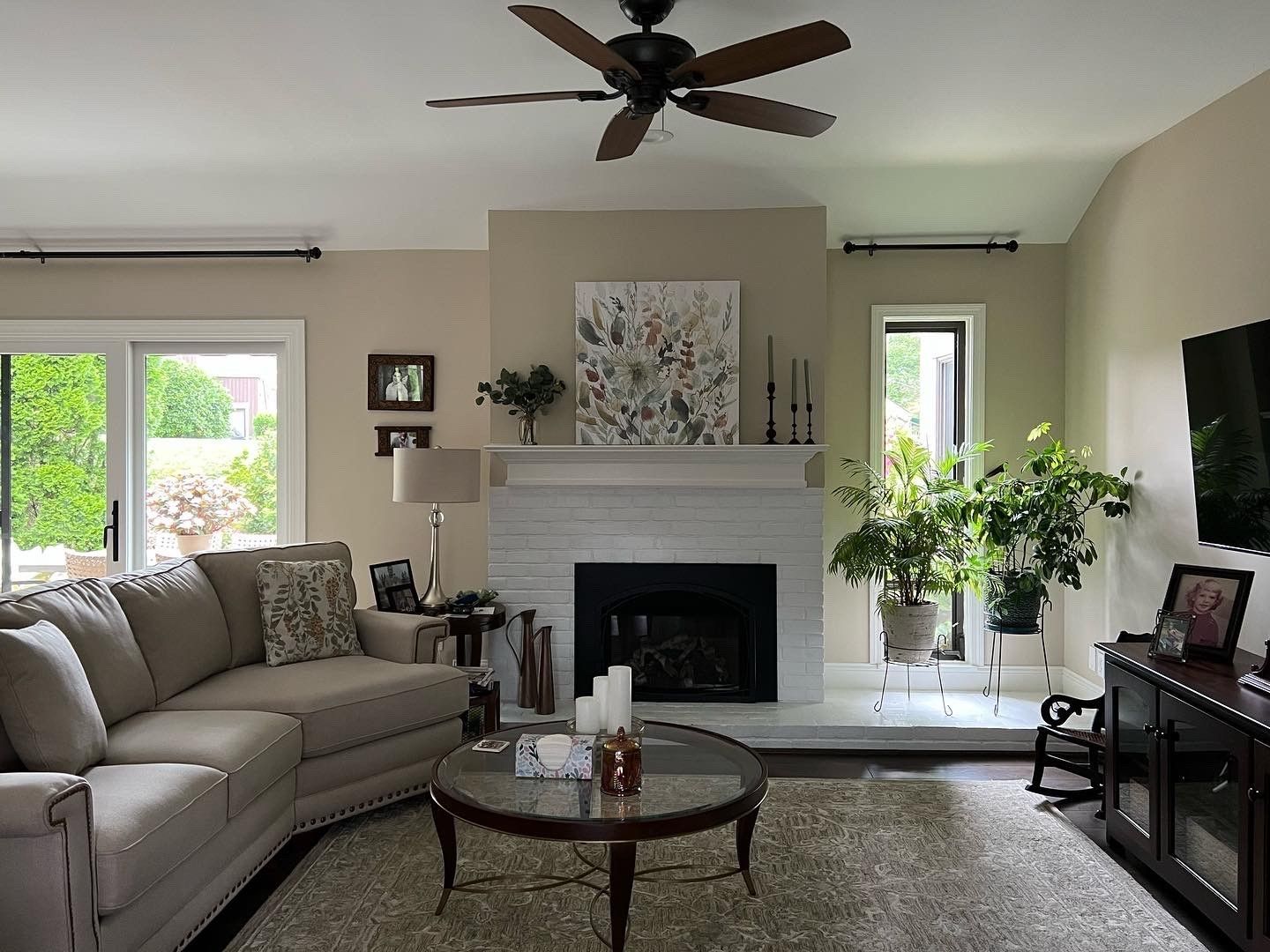 A living room with a fireplace and a ceiling fan