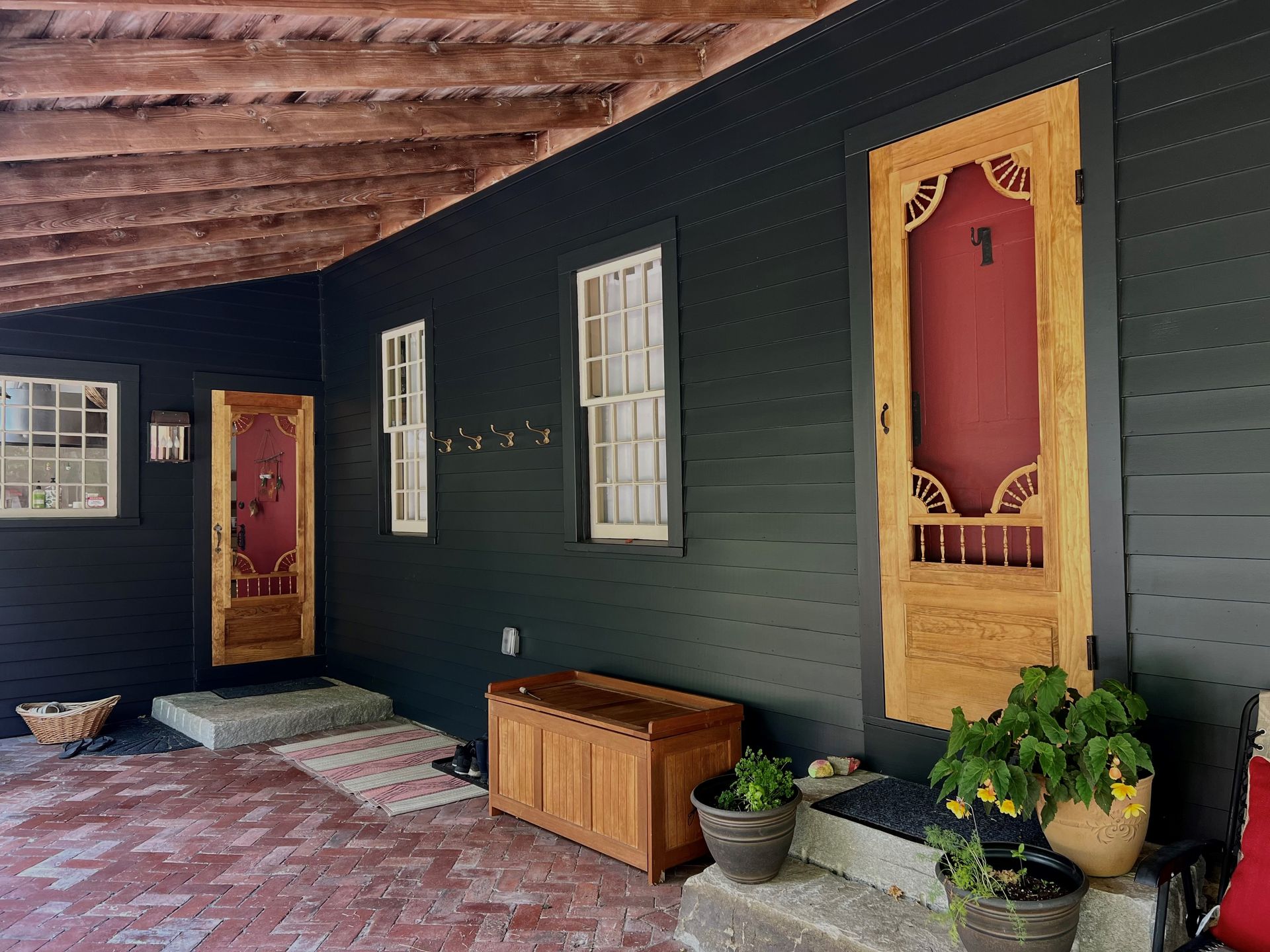A porch with a wooden bench and a screen door