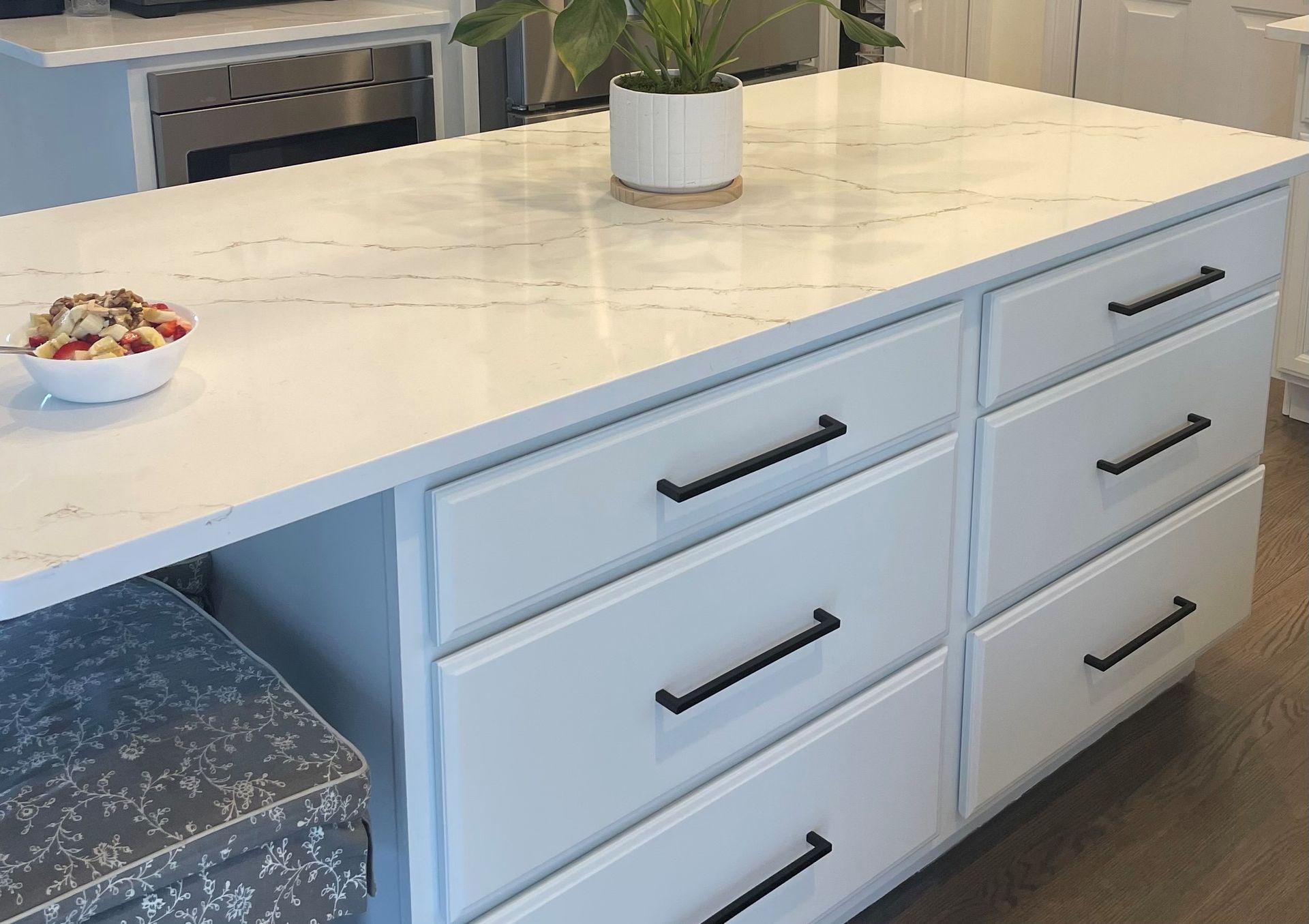 A kitchen island with drawers and a plant on top of it.