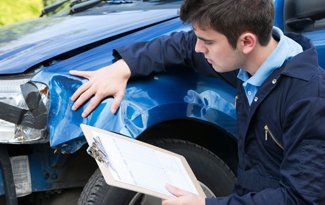 An expert examining the collision damage