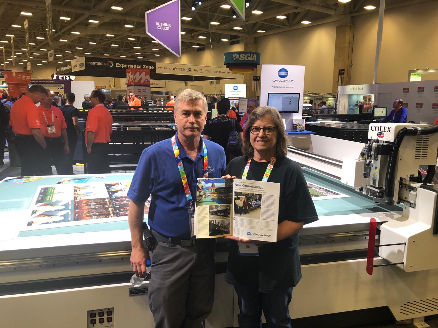 two people showing printed material