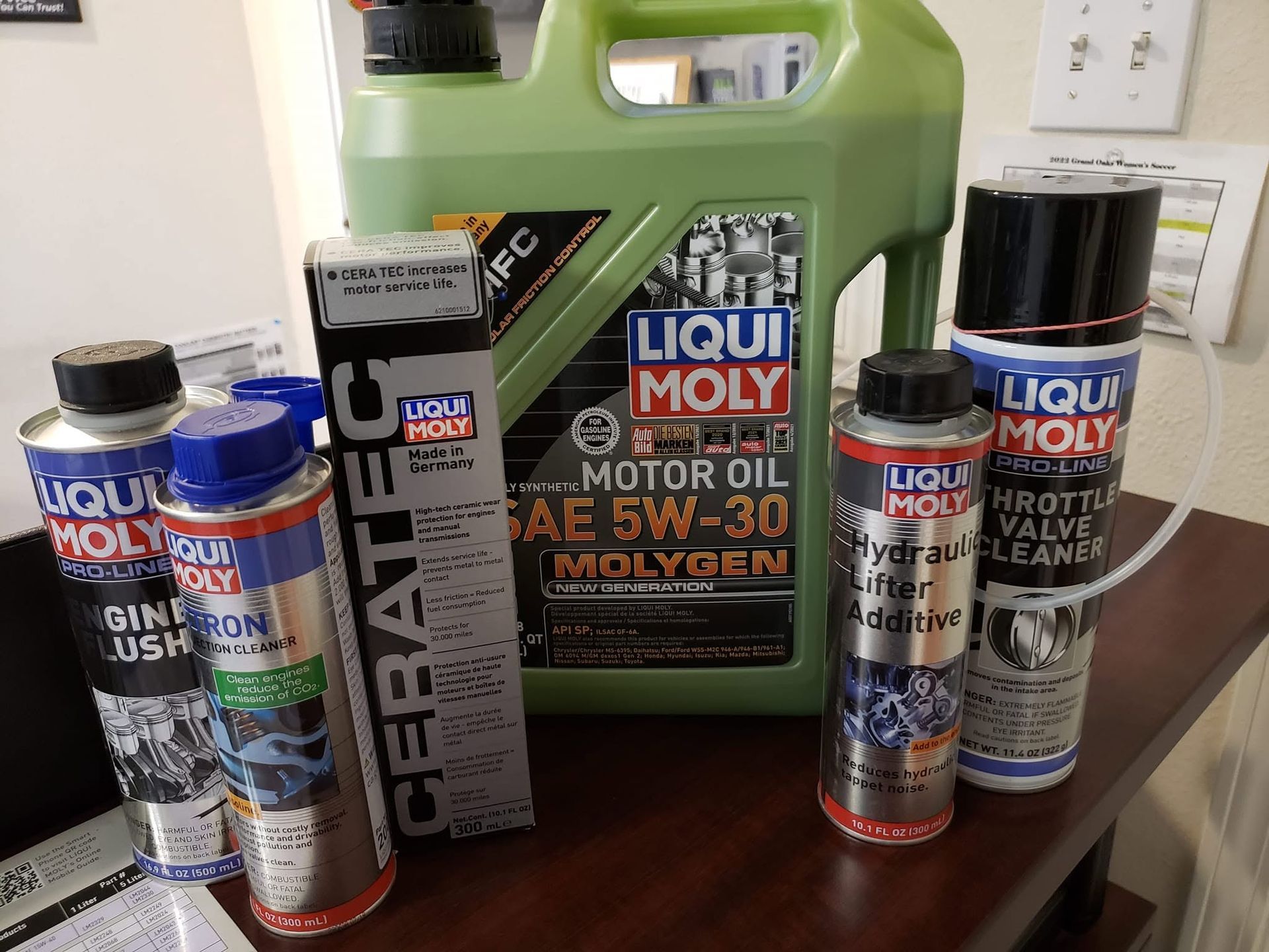 LIQUI MOLY motor oil and additives displayed on a countertop, including a large green oil jug and several bottles.