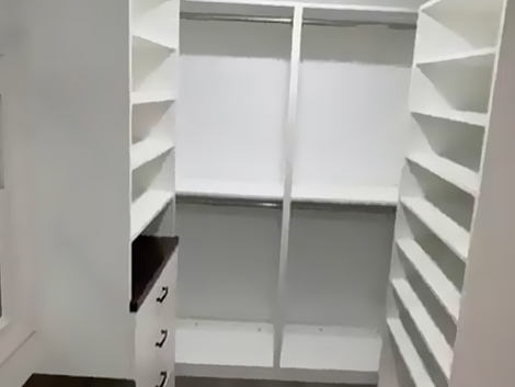 A walk-in closet with lots of shelves and drawers.