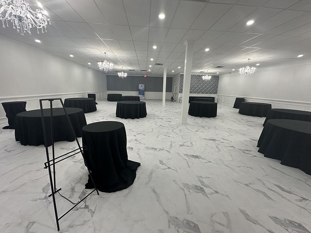A large room with tables and chairs set up for a party.