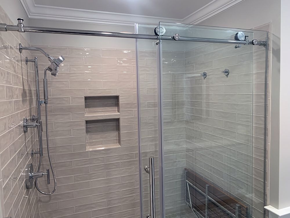 A bathroom with a sliding glass shower door and a shower head.