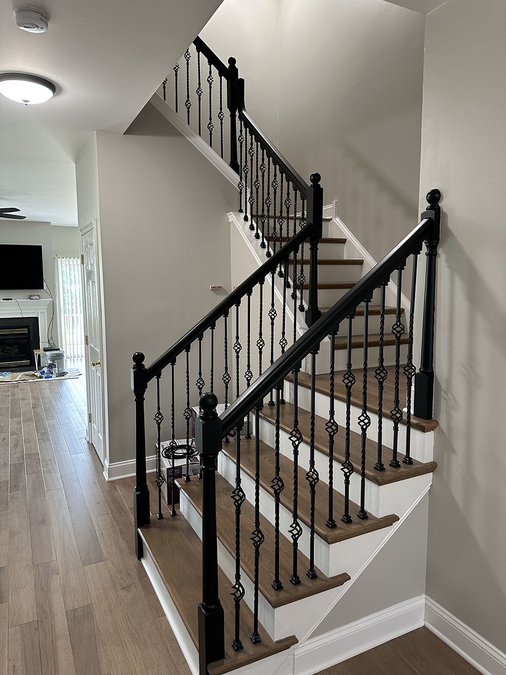 A staircase with a black railing and wooden steps in a house.