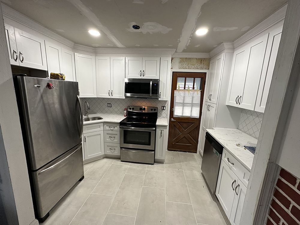 A kitchen with white cabinets and stainless steel appliances.