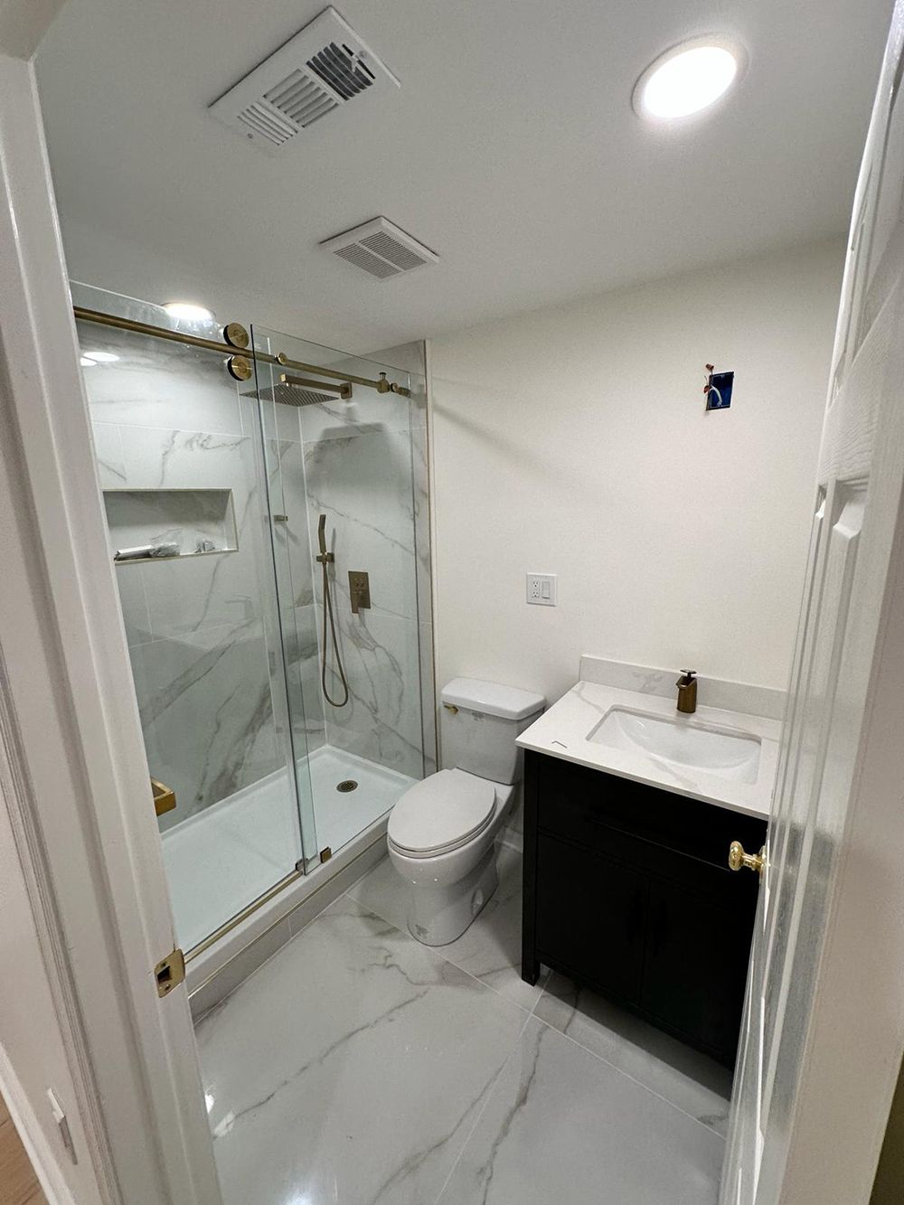 A bathroom with a toilet, sink and shower.