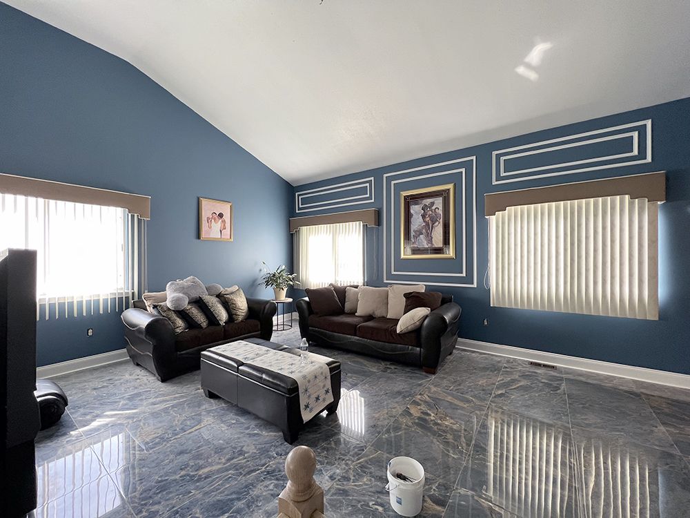 A living room with blue walls and a vaulted ceiling