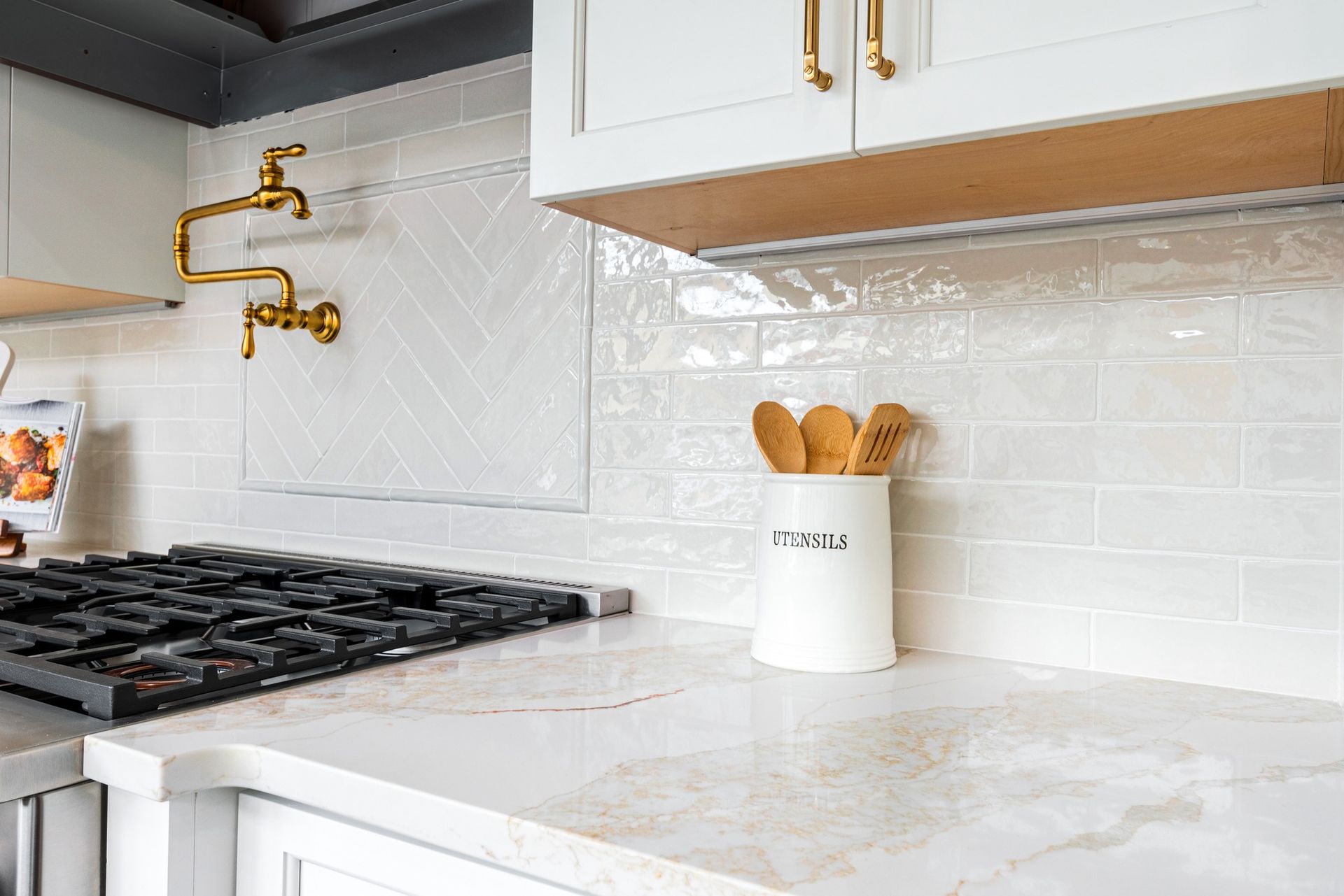 A kitchen with white cabinets and a stove top oven.
