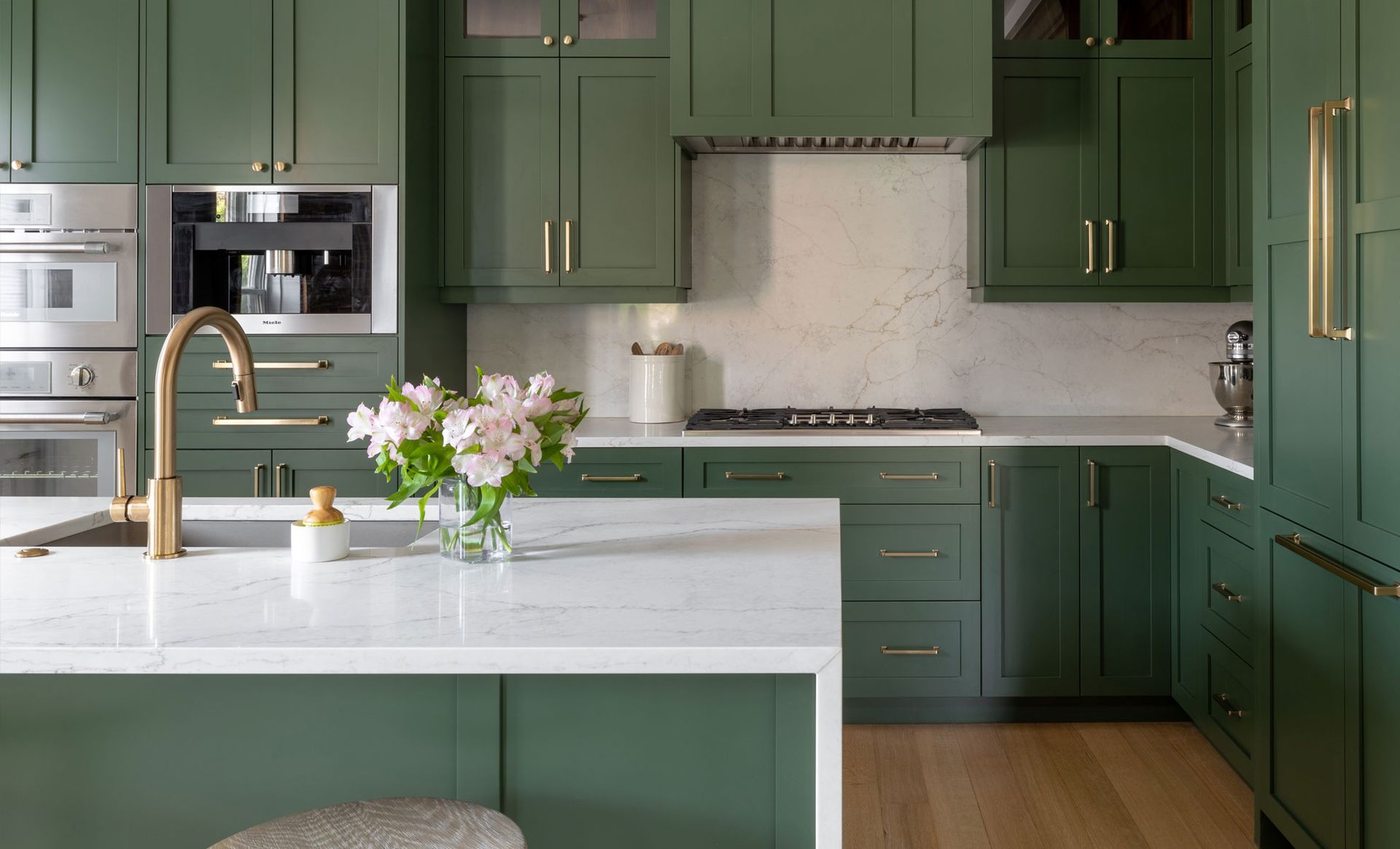 A kitchen with green cabinets and a white counter top.