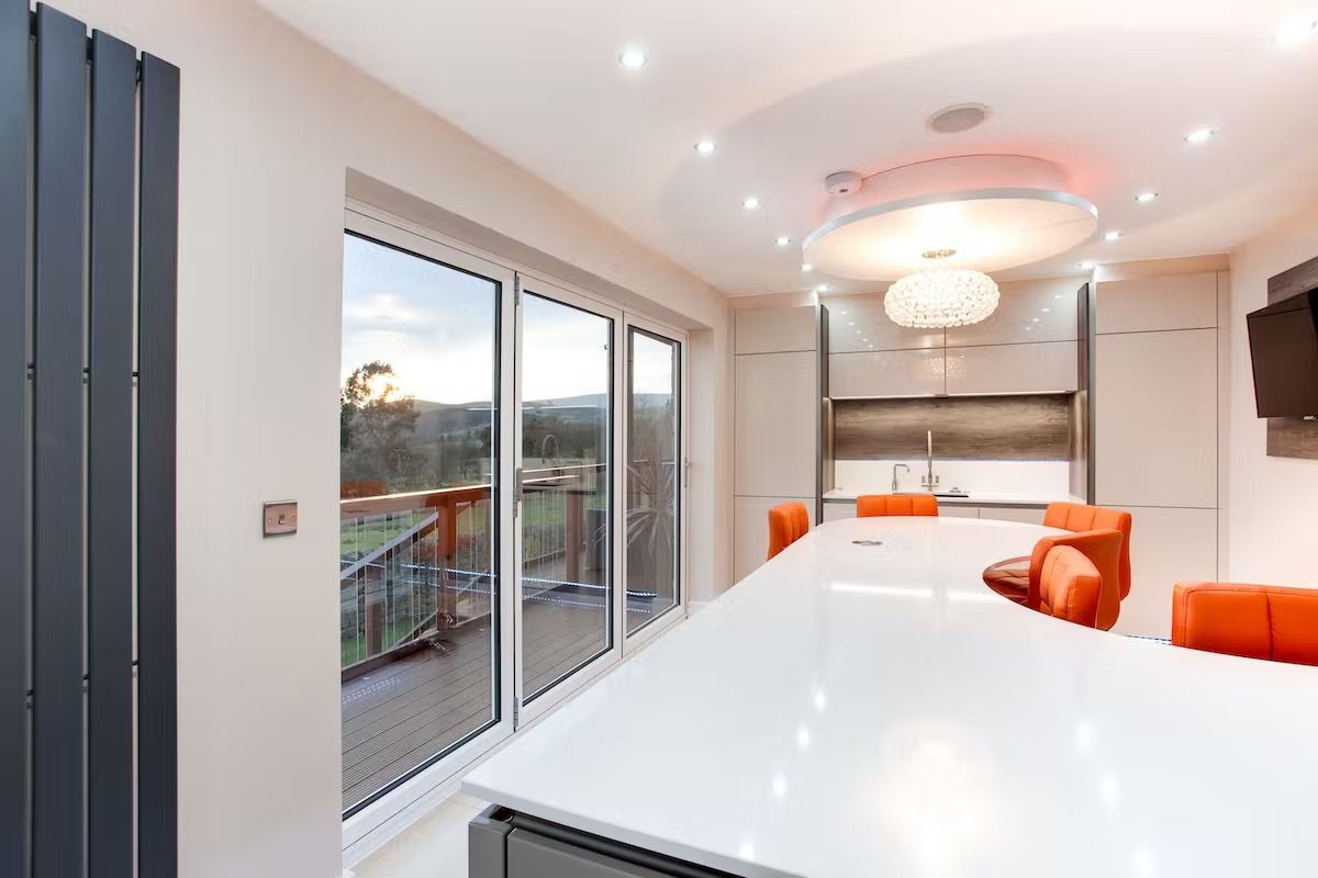 A kitchen with a large island and sliding glass doors leading to a balcony.