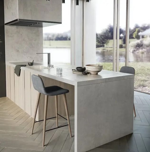A kitchen with a large island and two stools