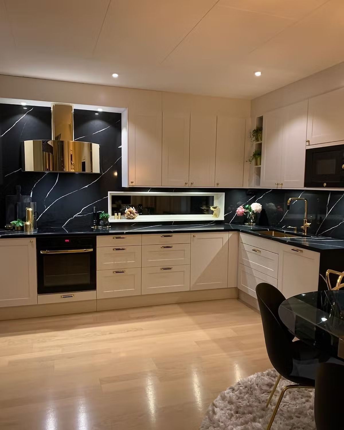 A kitchen with white cabinets and black counter tops