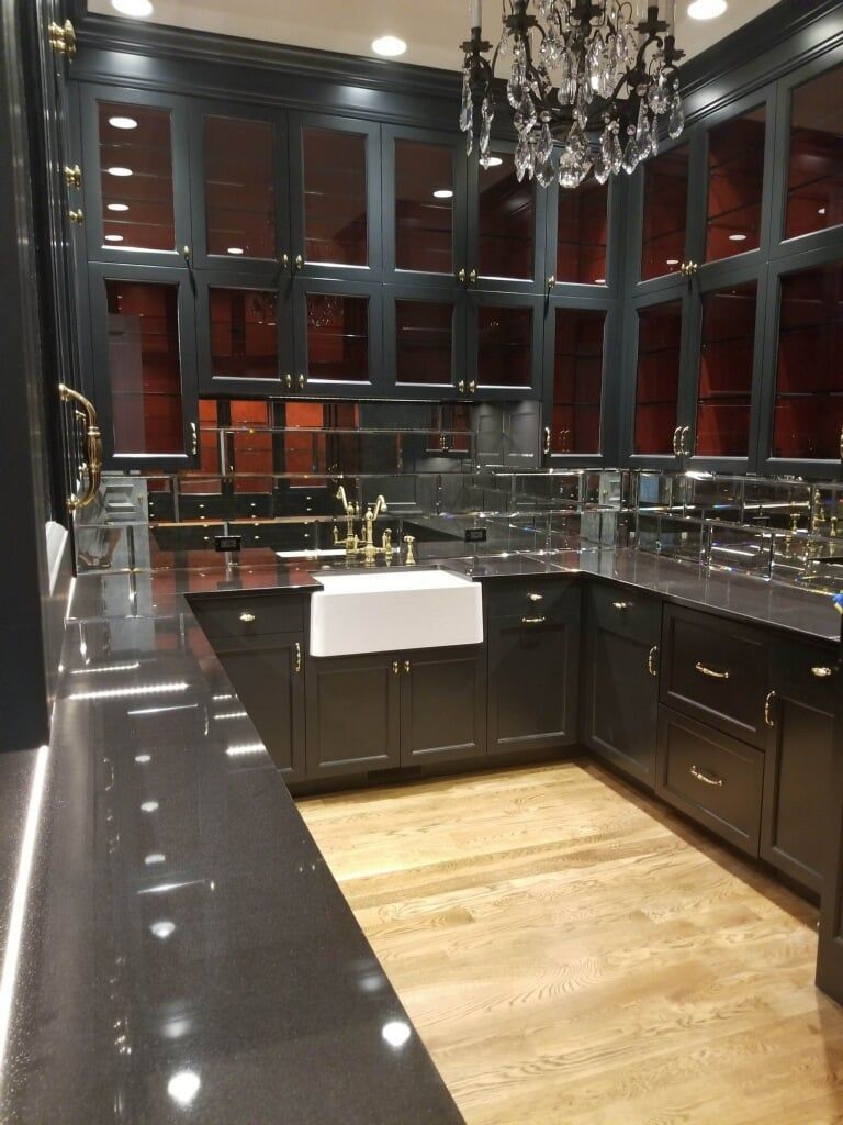 A kitchen with black cabinets and a white sink