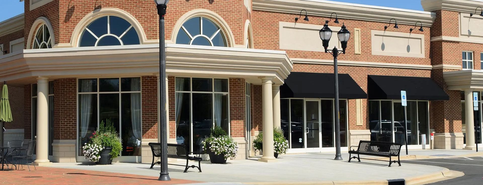 A brick building with a lot of windows and black awnings.